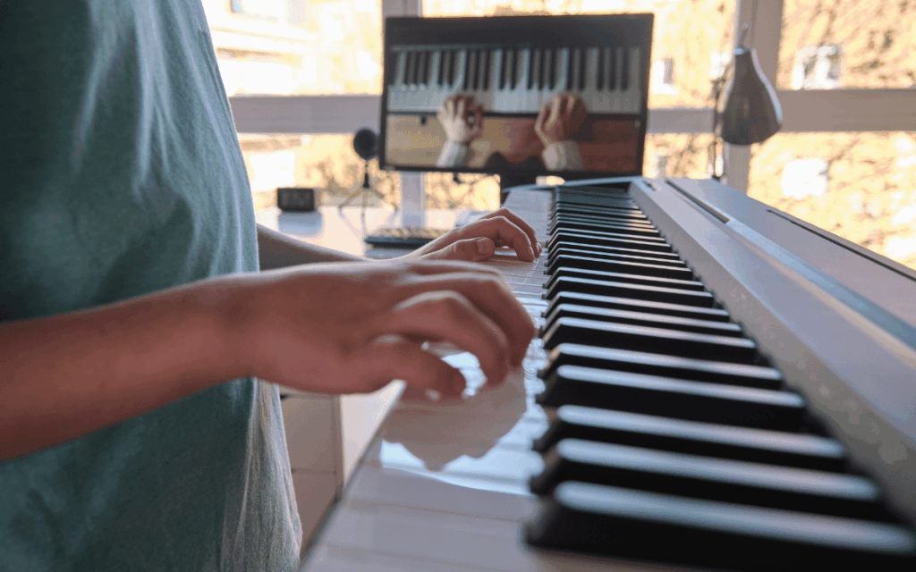 Profesor de piano enseñando técnicas básicas en un curso online para principiantes